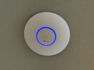Gemonteerde wifi-zender met een blauwe ring aan de wand