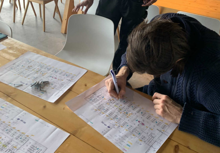De kabelroutes worden met de hand afgetekend op de plattegronden van het schip