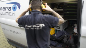 Medewerker van CameraInstallatie.nl pakt materiaal uit de bedrijfsbus
