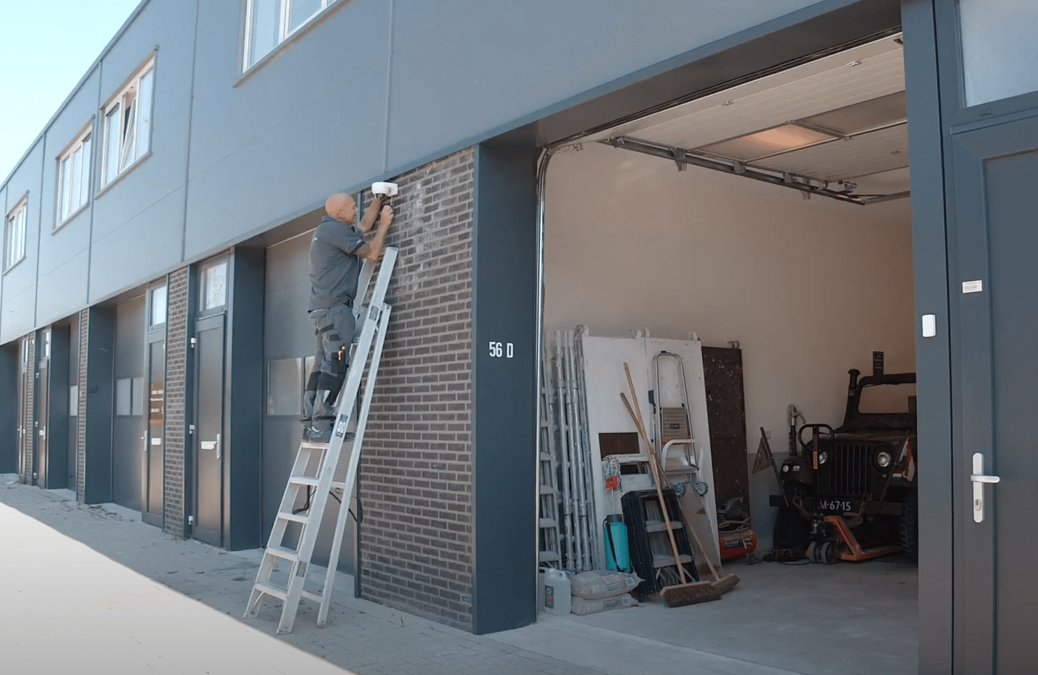 Monteur van CameraInstallatie.nl op een ladder voor een bedrijfspand