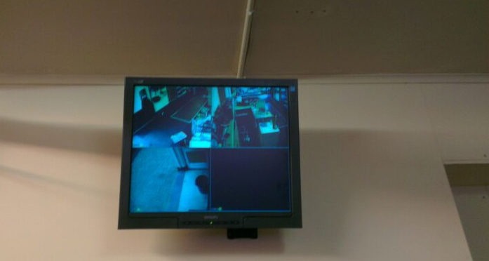 Monitor aan het plafond met vier beeldvlakken van de camera’s in de winkel