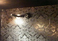 Zwarte dome-camera weggewerkt tegen een donker gedessineerd plafond in de kledingwinkel, waardoor de camera nauwelijks opvalt