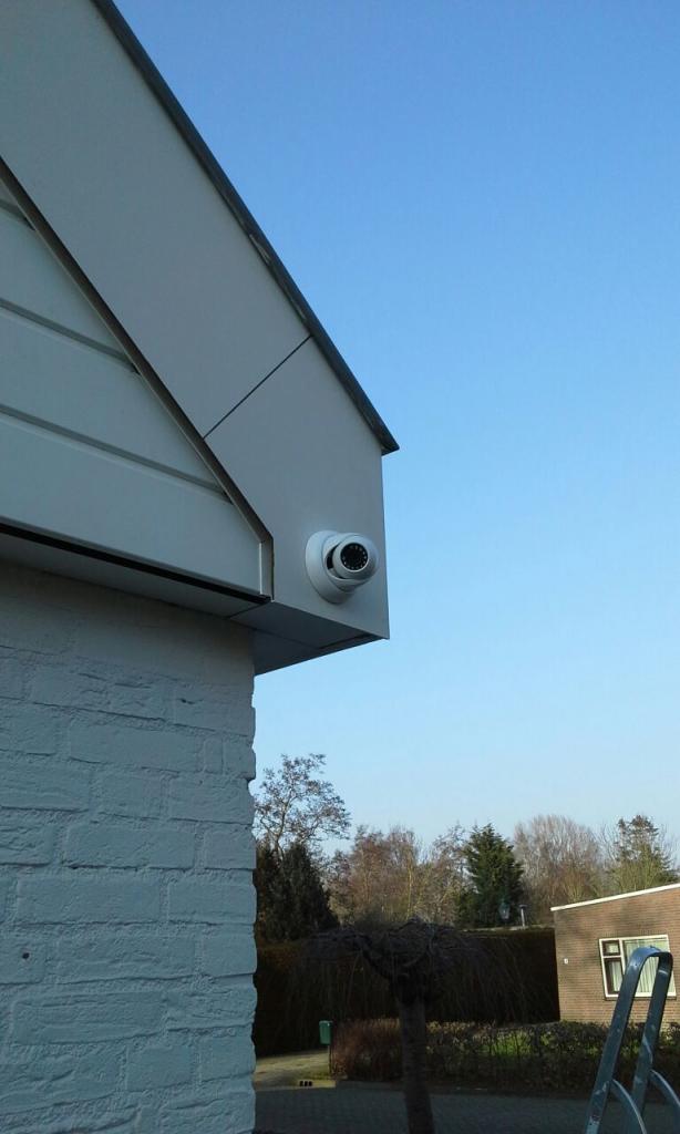 Buitencamera onder de punt van het dakoverstek van een woning