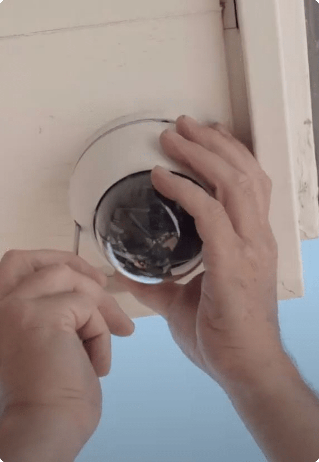 Monteur plaatst een dome-camera in de dakrand boven de entree van een woning