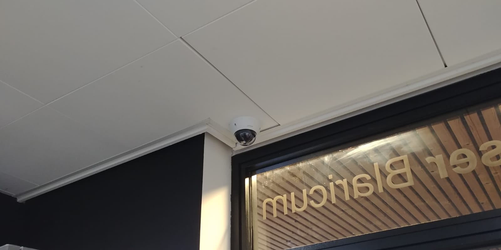 Dome camera in een systeemplafond vlak boven de entree van een winkel