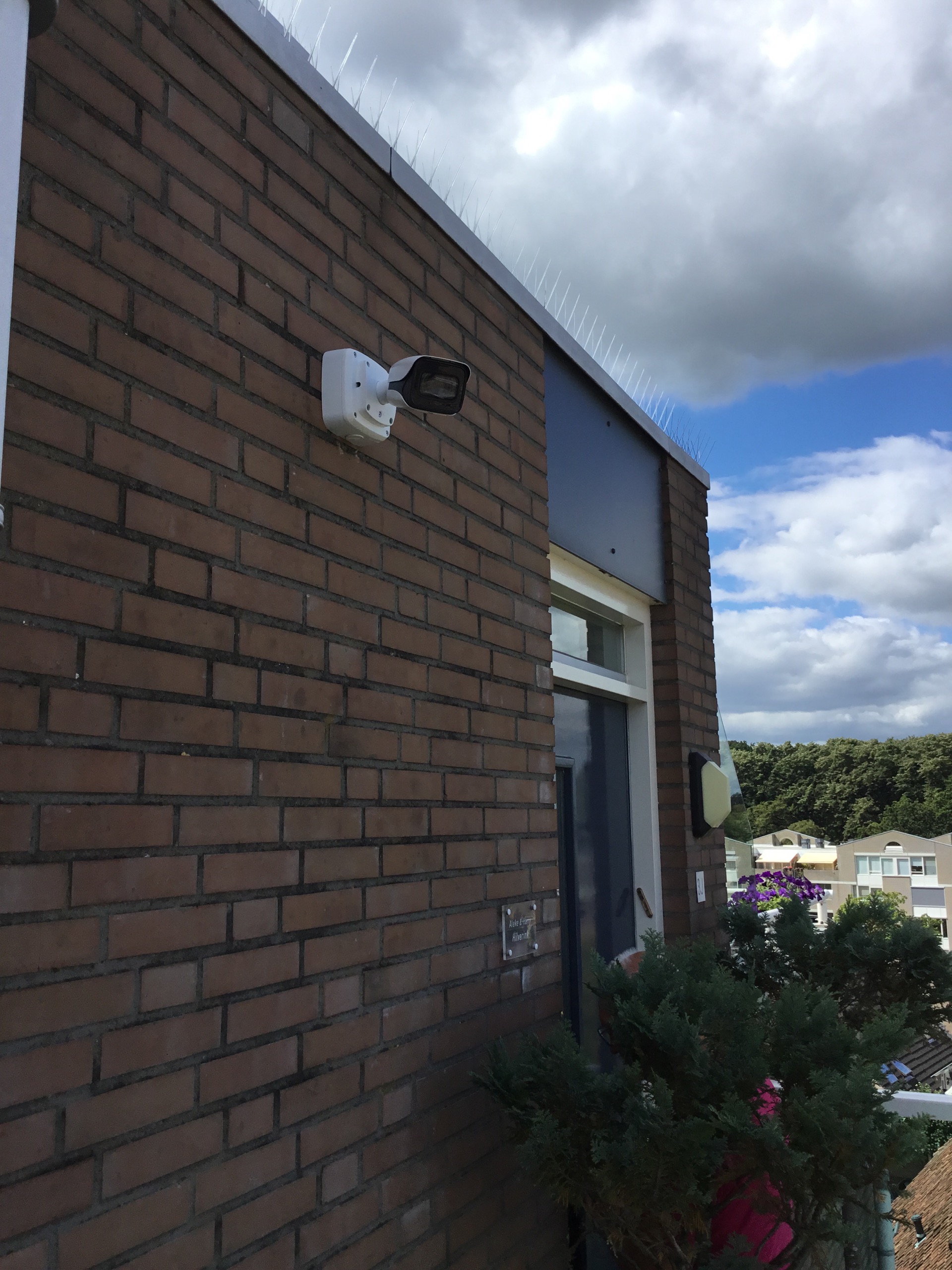 Camera aan een bakstenen gevel met uitzicht over de omgeving
