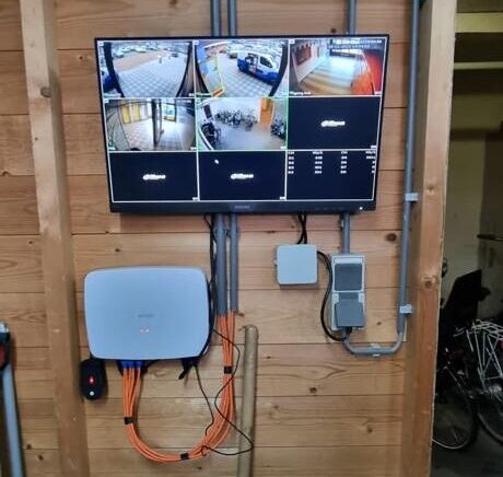 Meekijkscherm en netwerkrecorder tegen een houten wand in de bergingsruimte van een VvE in Rotterdam