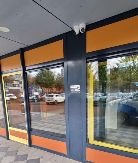 Bewakingscamera boven de gezamenlijke entree aan de buitengevel van het appartementengebouw