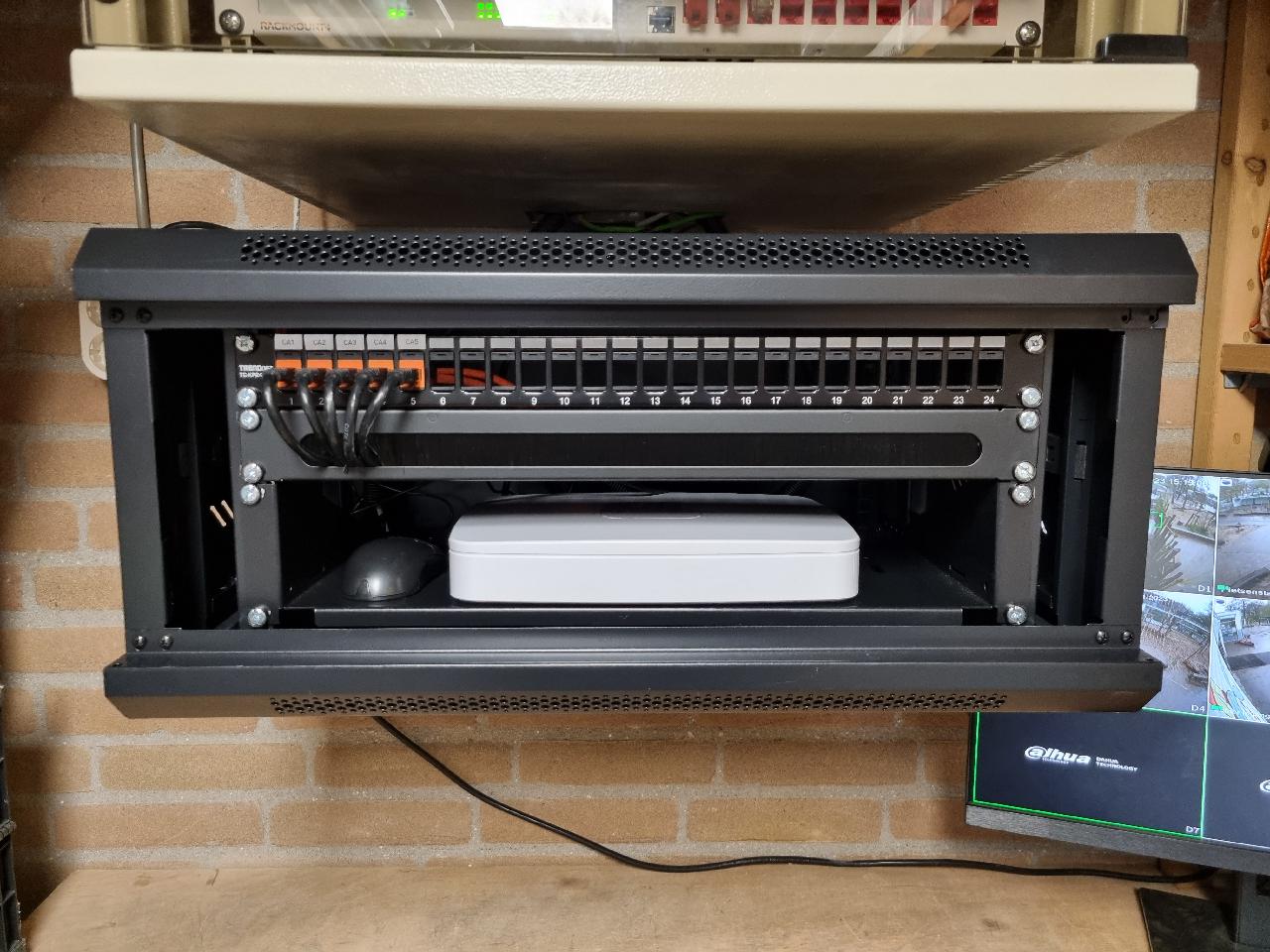 Open wandkast met patchpaneel en een witte recorder in de techniekruimte van een school in Zwolle (eigen werk)