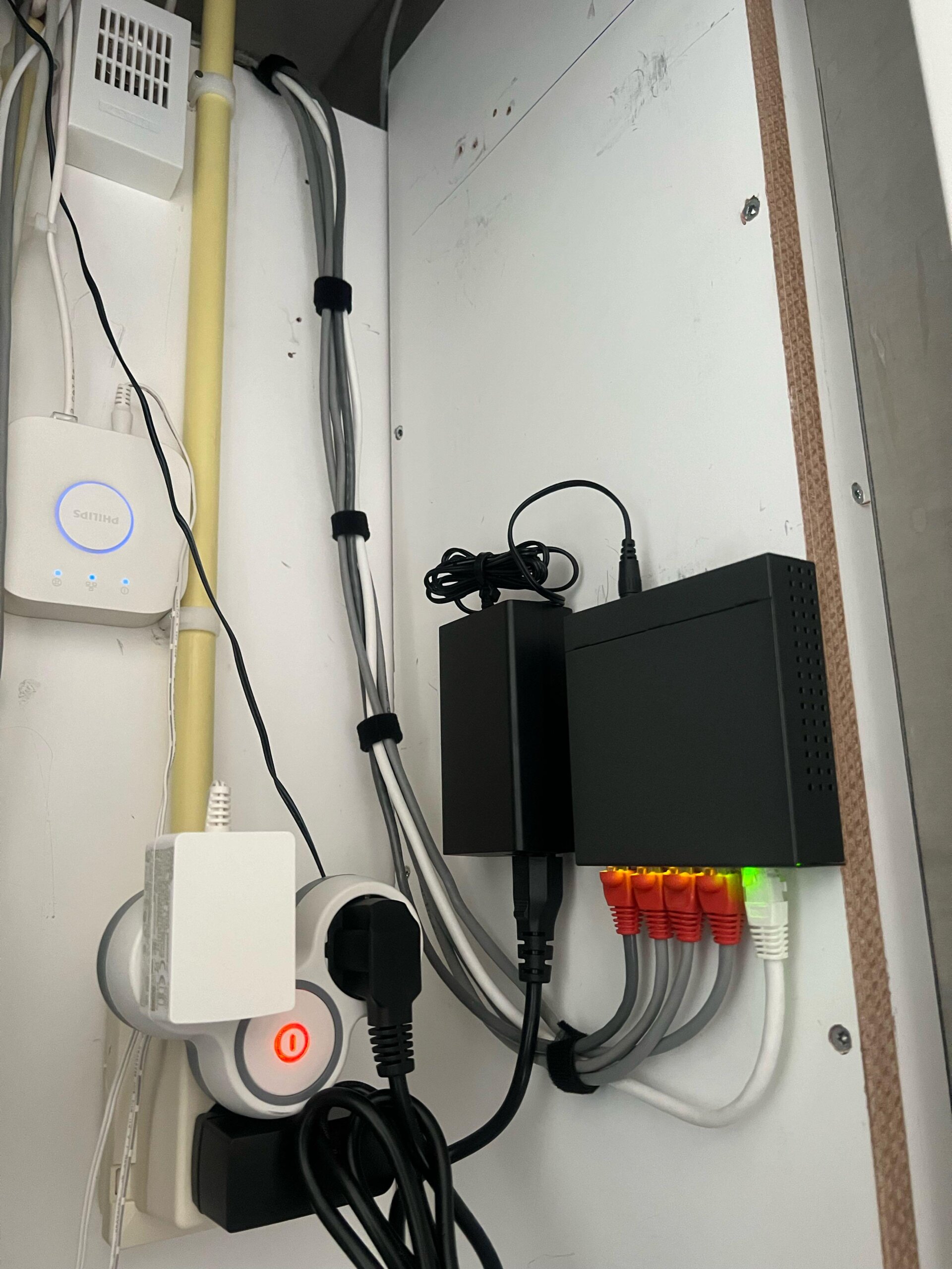 Technische kast met de recorder, netwerkkabels op de PoE-poorten en een stekkerblok