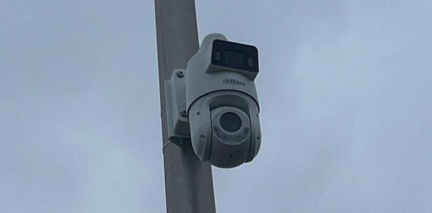 Slimme Dahua PTZ-camera met dubbele lens gemonteerd op een mast, gericht op het eigen terrein van een woning