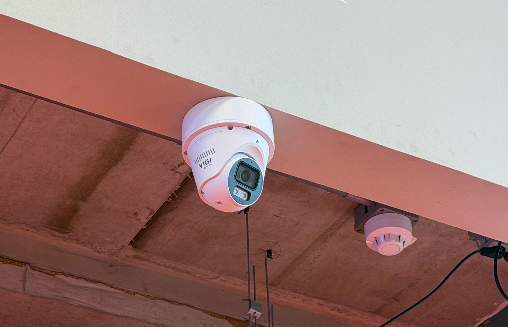 VIGI by TP-Link turretcamera strak tegen het plafond gemonteerd naast een rookmelder, kabel netjes weggewerkt
