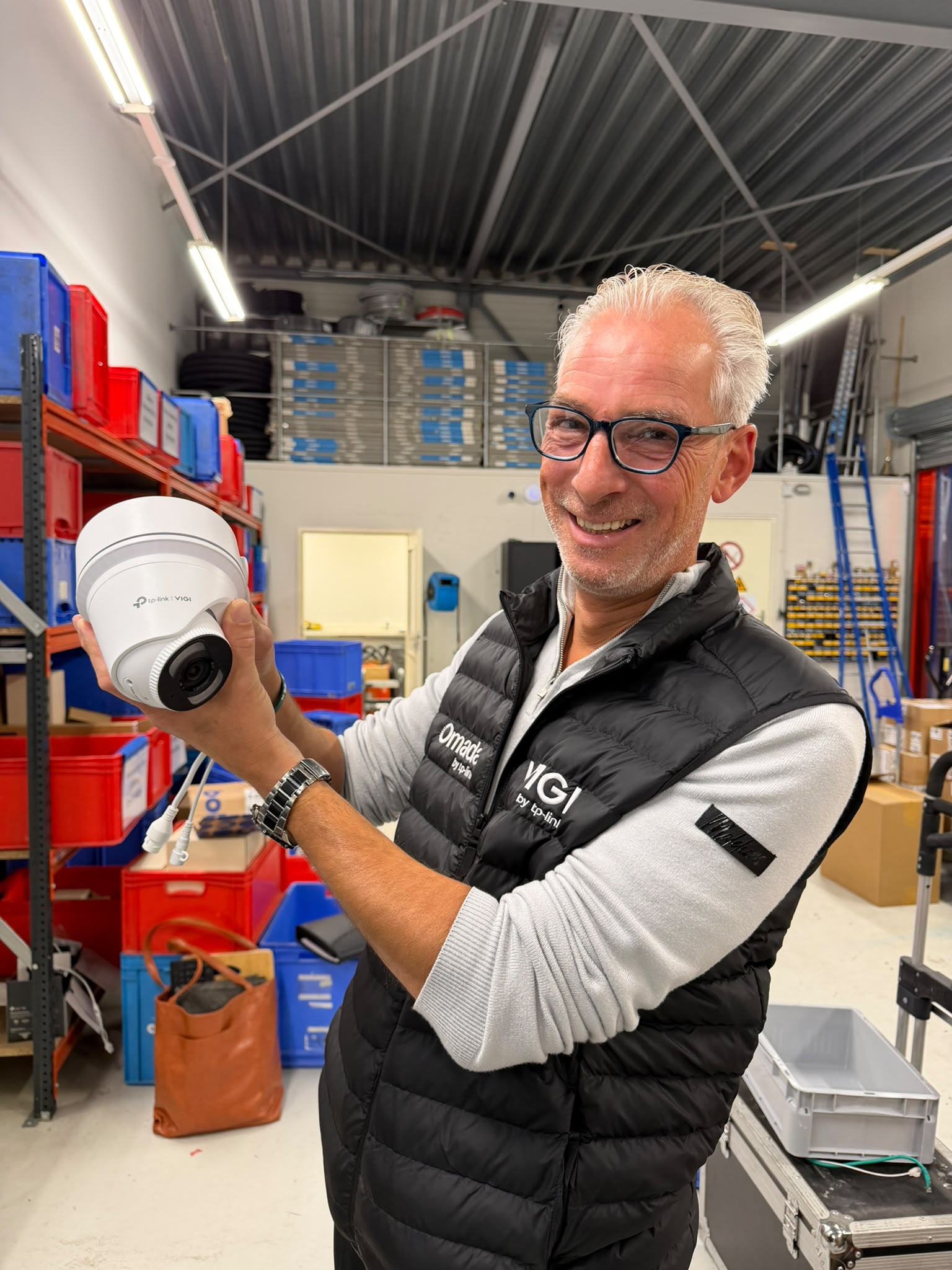 Patrick van VIGI met een VIGI-camera in de hand in het magazijn van CameraInstallatie