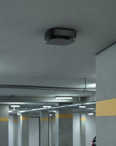 Dome-camera aan het plafond van een ondergrondse parkeergarage met betonnen pilaren en verlichte rijbaan
