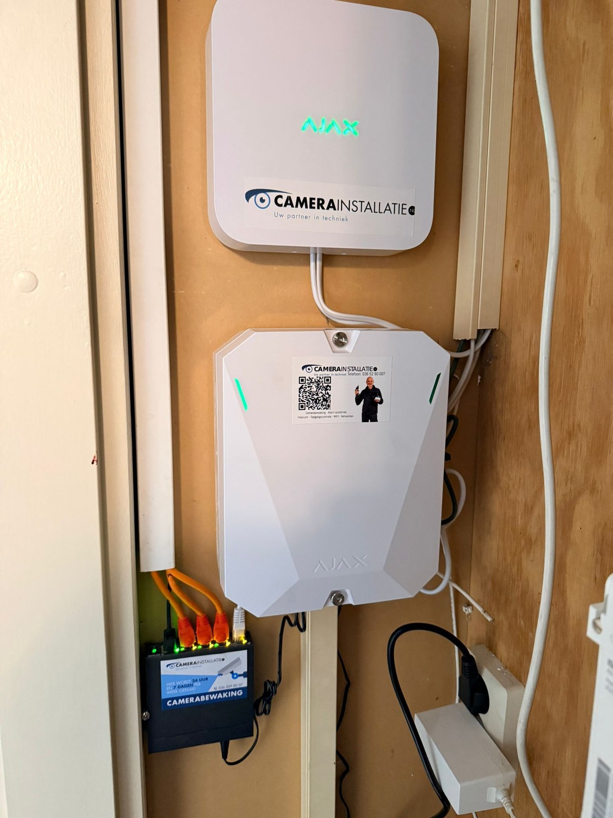 Een Ajax-hub met CameraInstallatie-branding tijdens de installatie, het hart waar de DoorBell mee samenwerkt