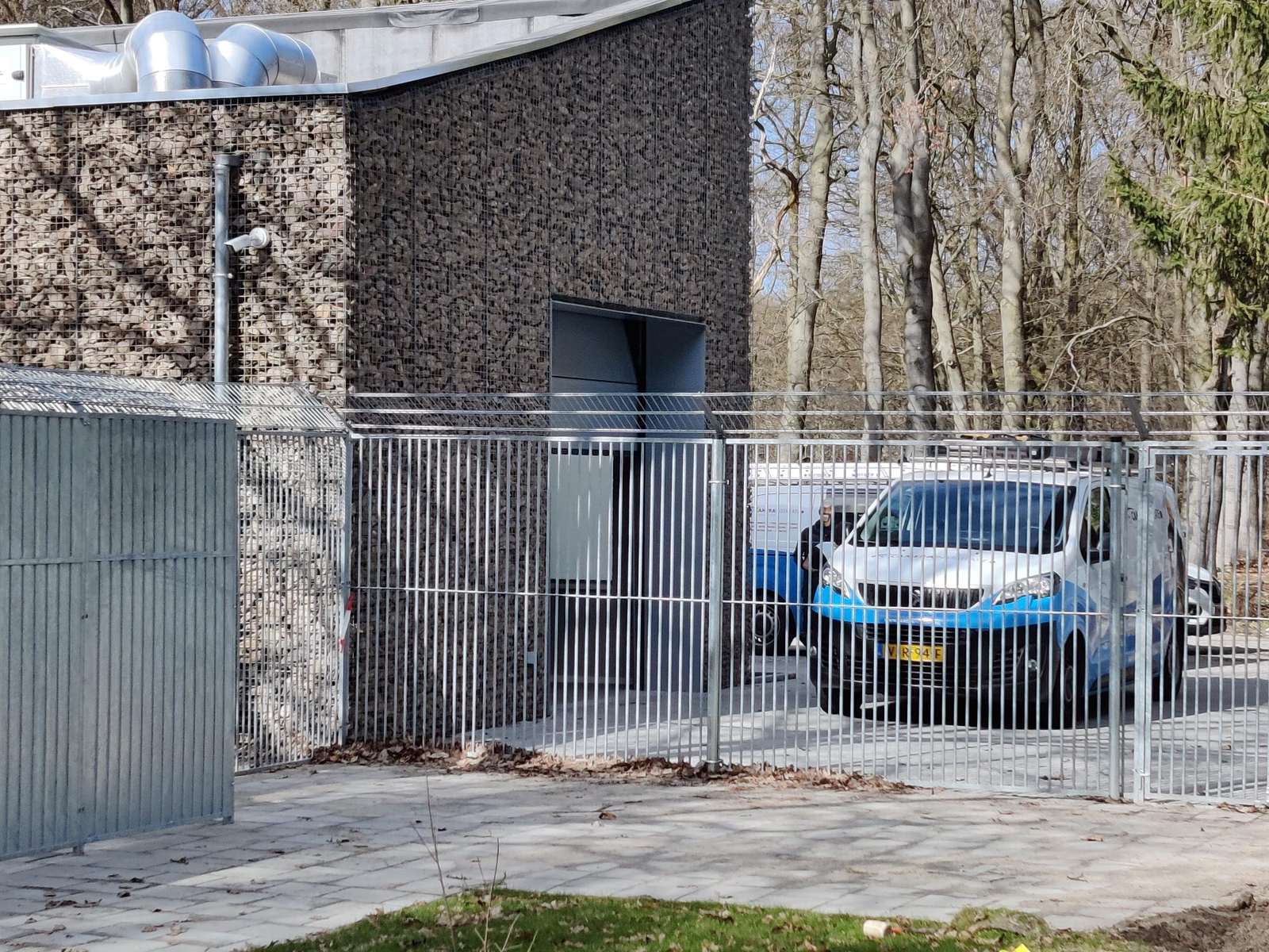 Omheind bedrijfsterrein met stalen hekwerk en een dichte toegangspoort