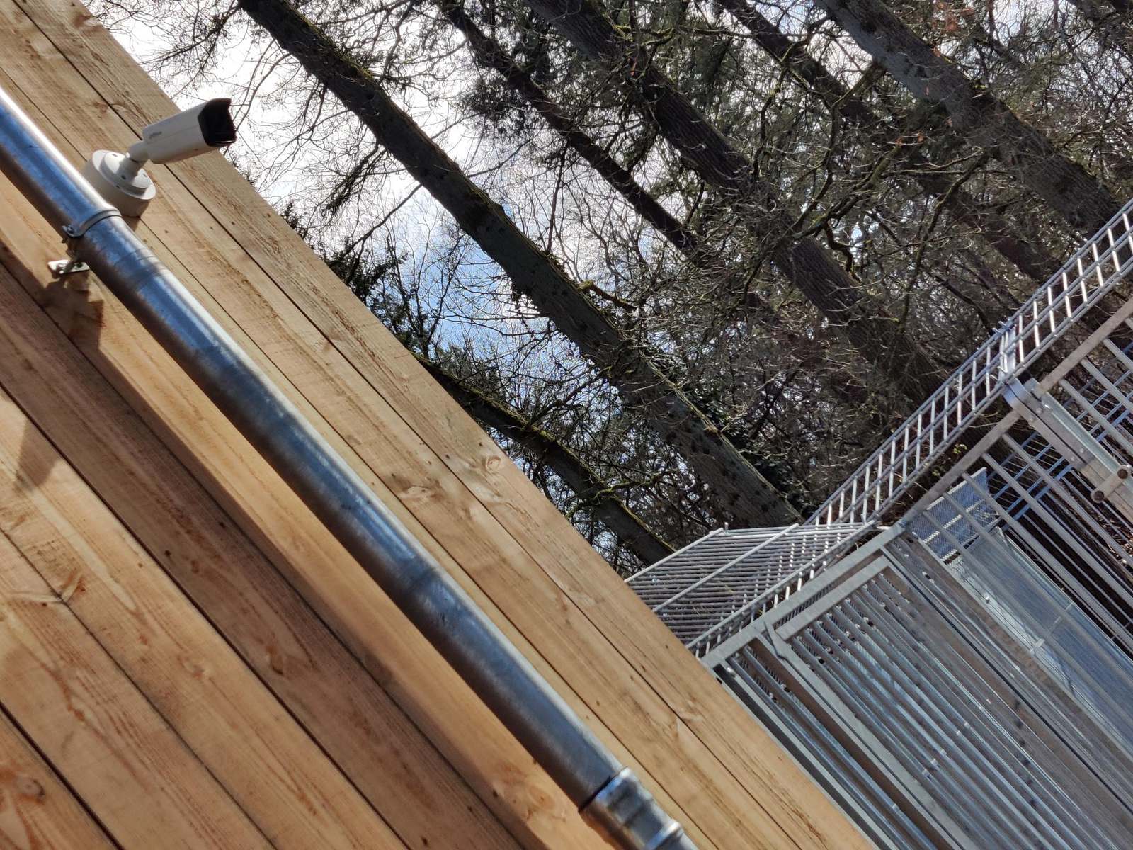 Buitenapparatuur netjes gemonteerd onder een houten dakrand, kabel volledig uit het zicht