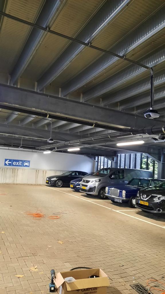 Camera aan het plafond van een overdekte stalling met auto's eronder