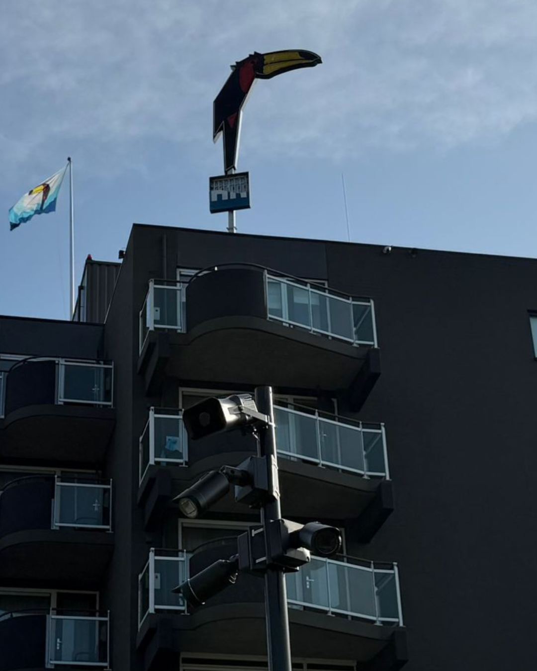 Camera's op een mast voor een gebouw, met zicht op de gevel en de toegangsweg