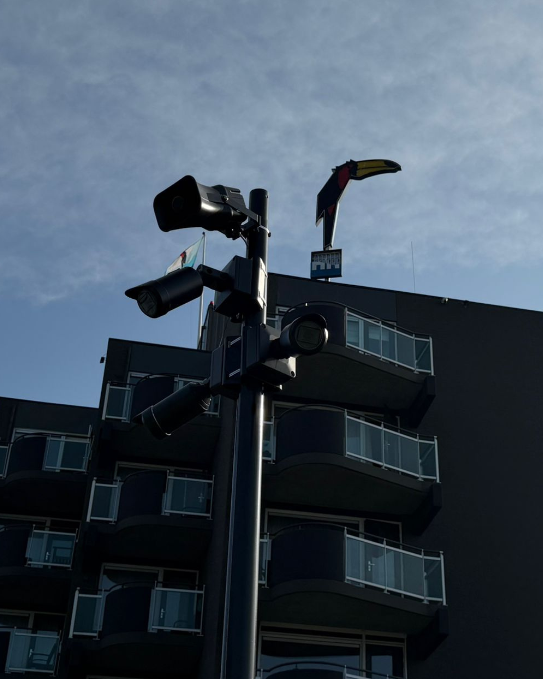 Camera's op een mast voor een hotelgebouw, gericht op de gevel en de buitenruimte