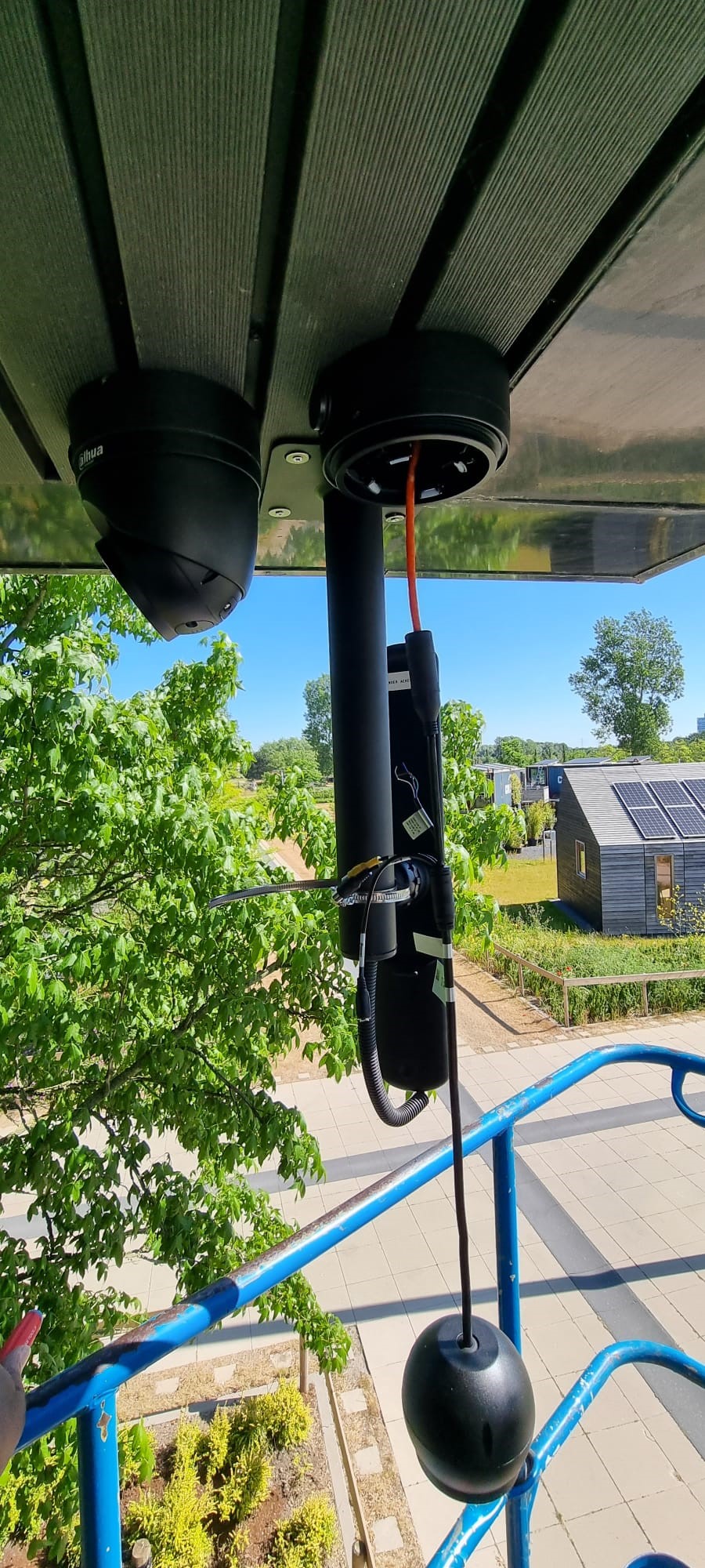 Twee Dahua-camera's in montage onder een dakrand met uitzicht over het terrein met zonnepanelen