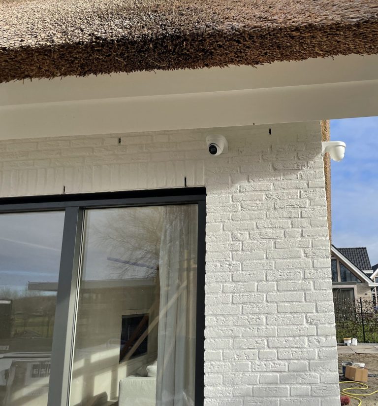 Twee witte dome-camera’s strak onder de dakrand van een nieuwbouwwoning