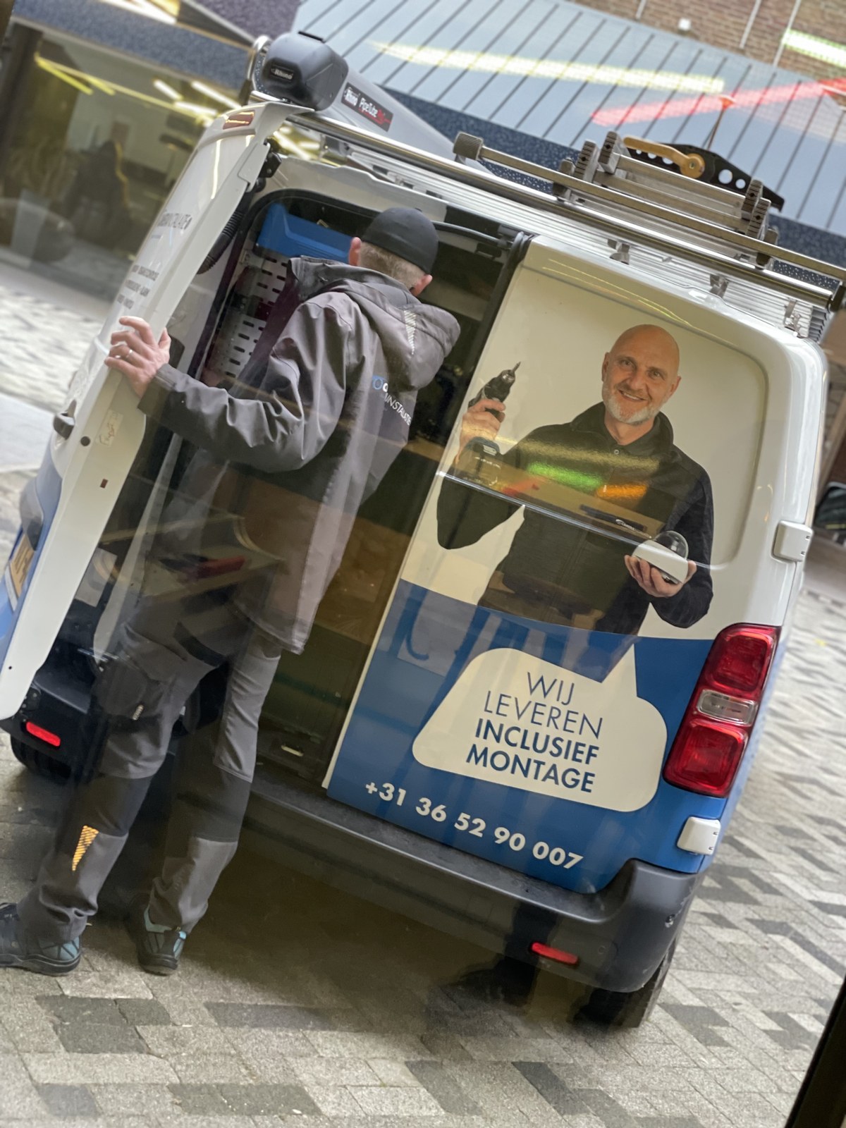 Monteur van CameraInstallatie pakt de melders uit de bedrijfsbus