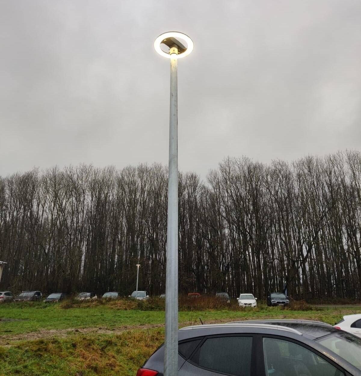 Brandend rond LED-armatuur op een nieuwe lichtmast boven het parkeerveld, in de schemering