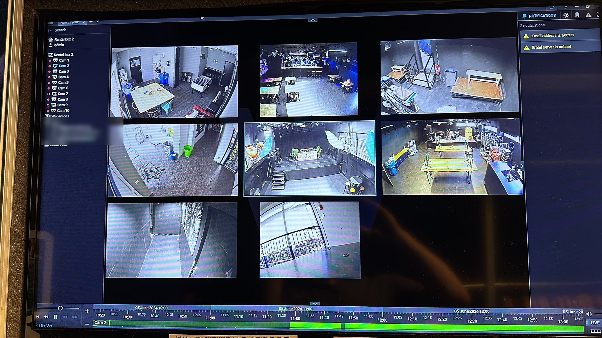 Beeldscherm met negen camerabeelden naast elkaar in een raster, links een camera-lijst van Cam 1 tot en met Cam 10 en onderaan een tijdlijn