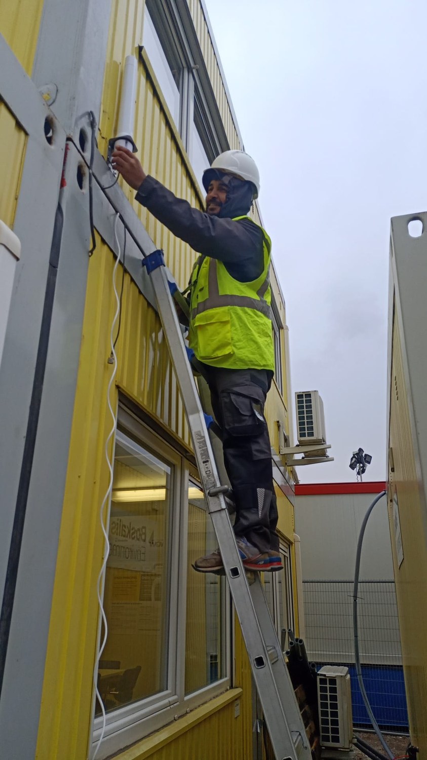Monteur werkt op de ladder aan de camera-installatie op locatie