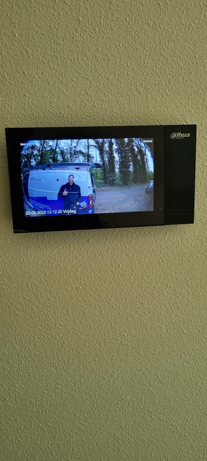 Binnenpost van de intercom laat live zien wie er bij de deur staat, met de servicebus op de oprit in beeld