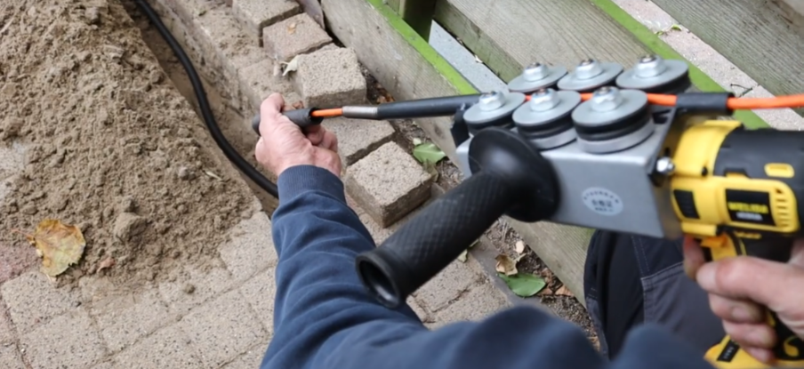 Monteur schiet een kabeldoorvoer door de muur