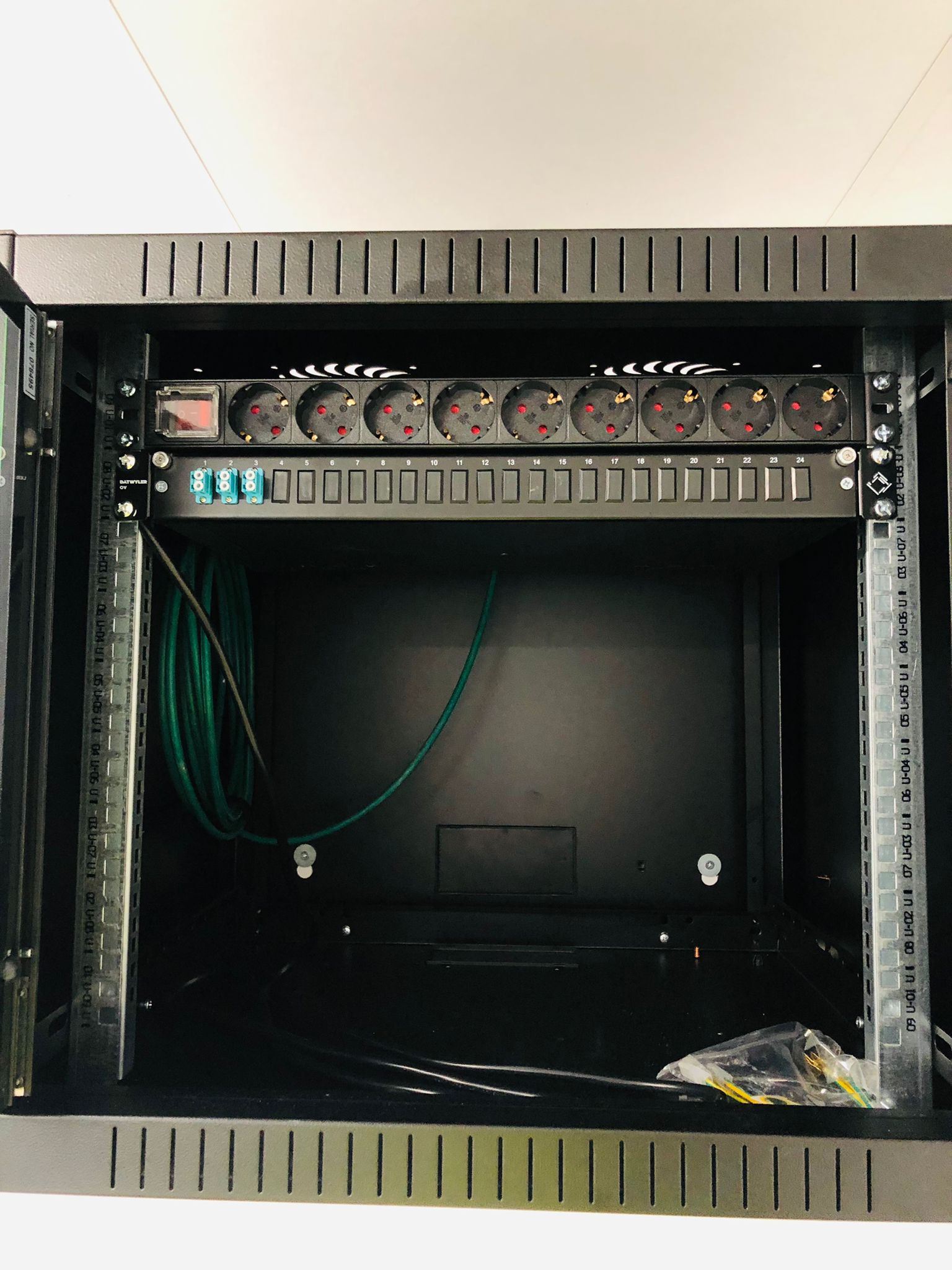 Lege wandpatchkast met patchpaneel, klaar om opgebouwd te worden