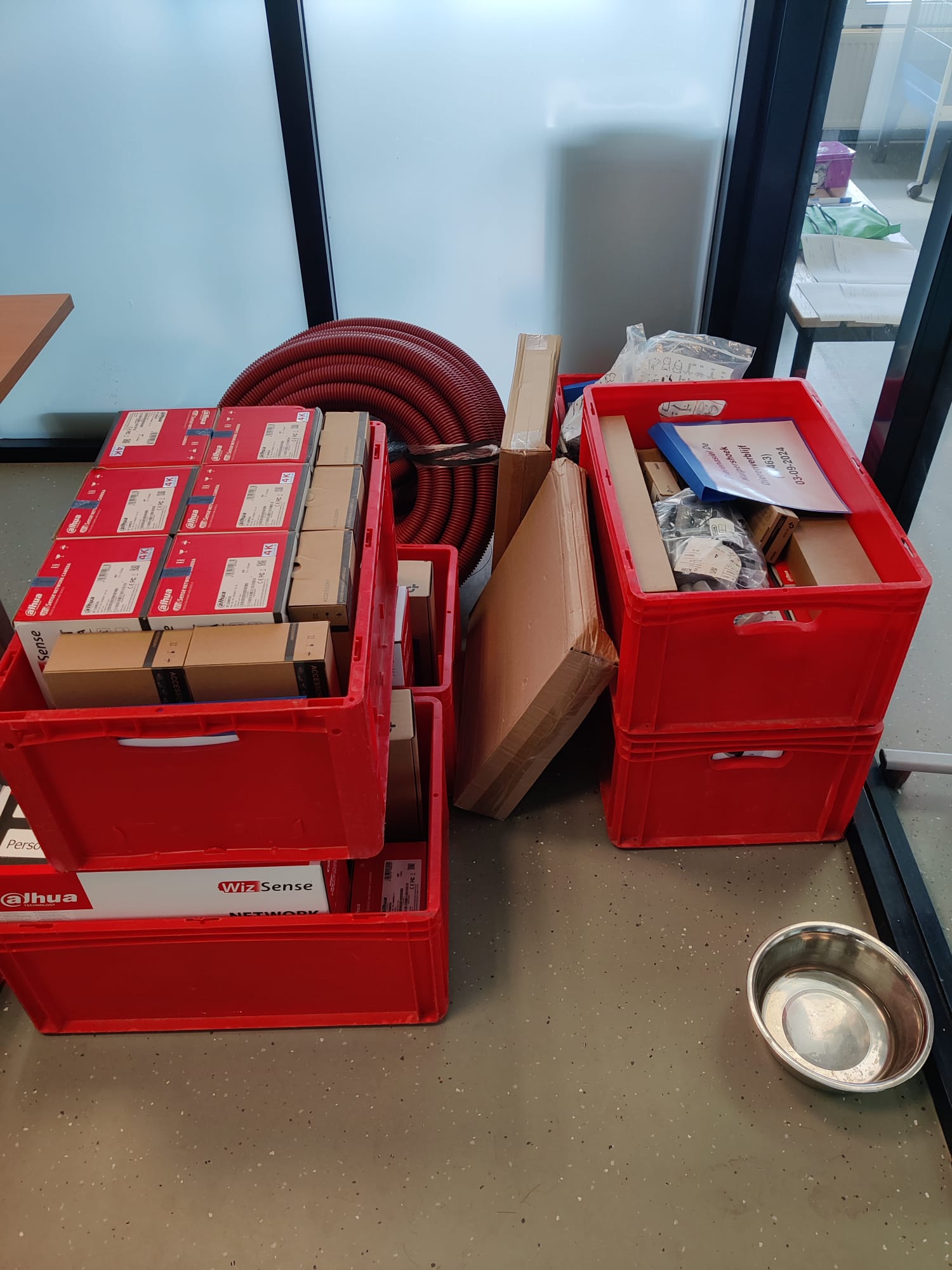 Materiaal voor het camerasysteem klaargezet in kratten, binnen op locatie