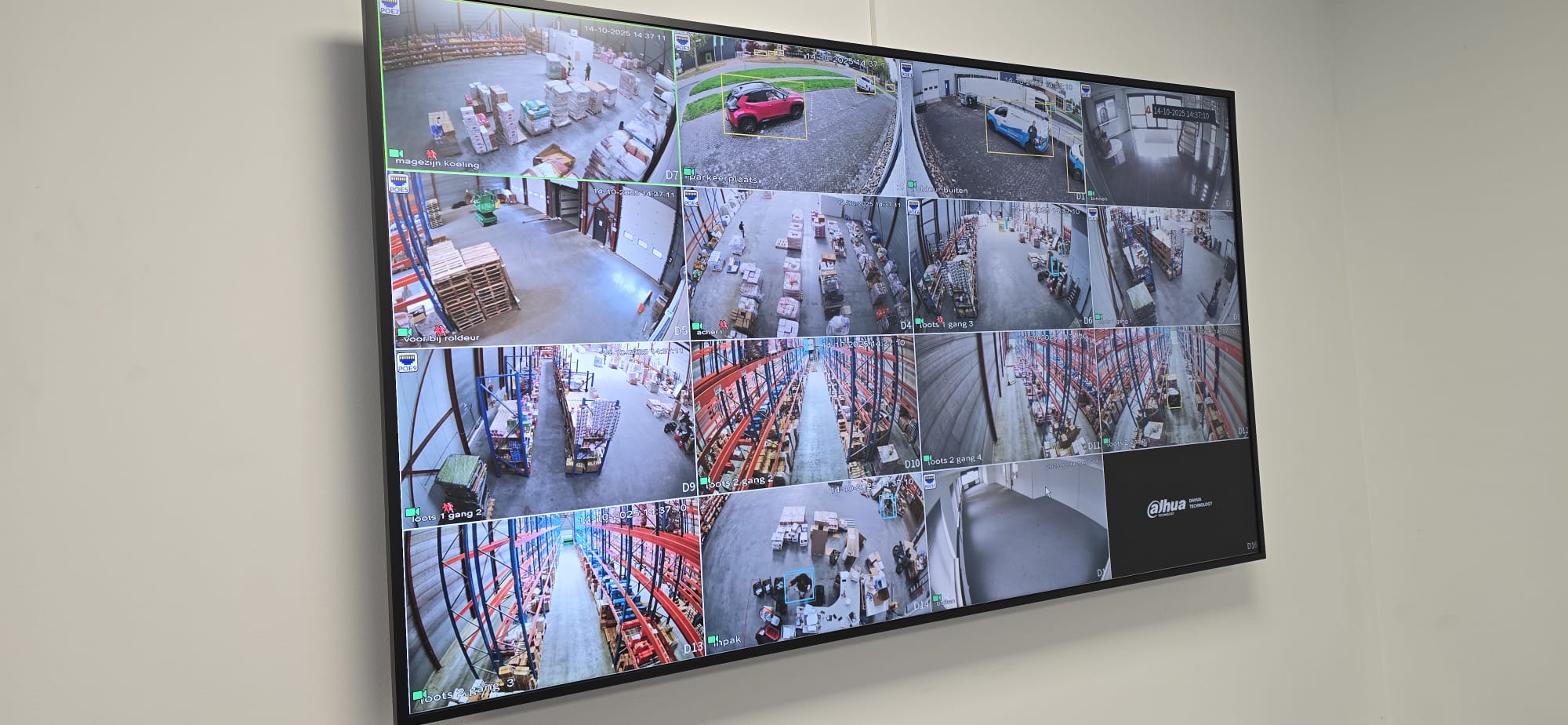 Groot wandscherm met zestien live camerabeelden van een magazijn