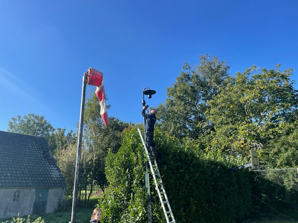 Onze eigen monteur monteert een camera onder de luifel van een station