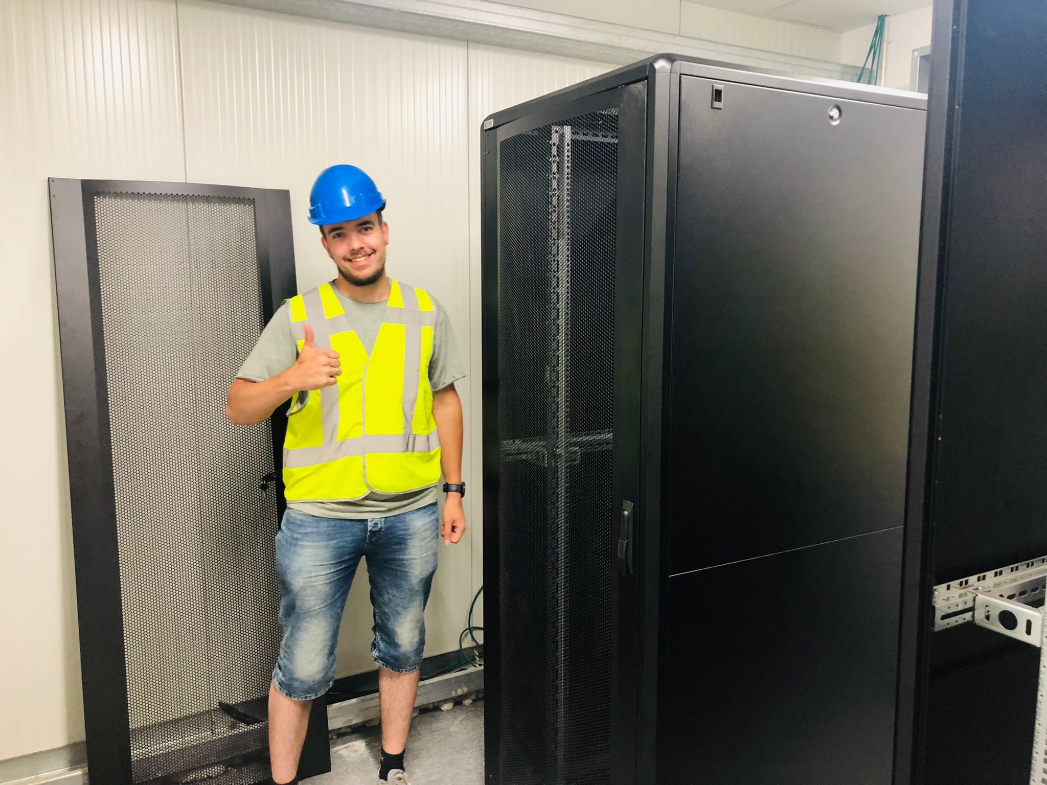 Monteur van CameraInstallatie bij de grote serverkasten in de technische ruimte