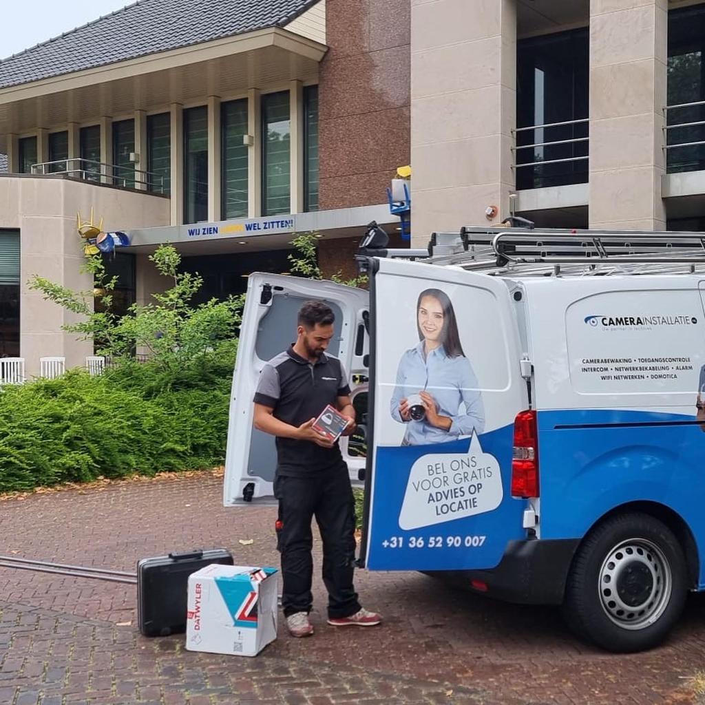 Servicebus van CameraInstallatie voor een pand, met een monteur die materiaal klaarzet
