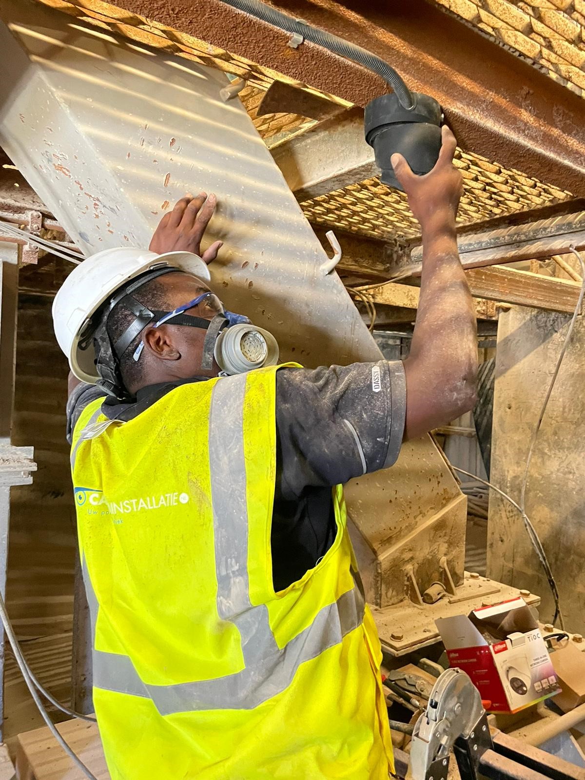 Monteur van CameraInstallatie werkt aan een camera in de plafondconstructie