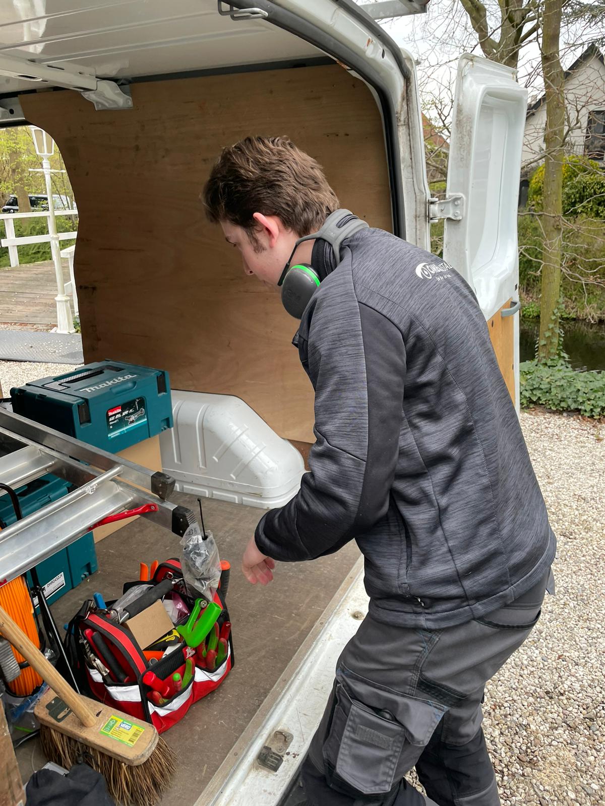 Monteur van CameraInstallatie pakt gereedschap uit de open servicebus