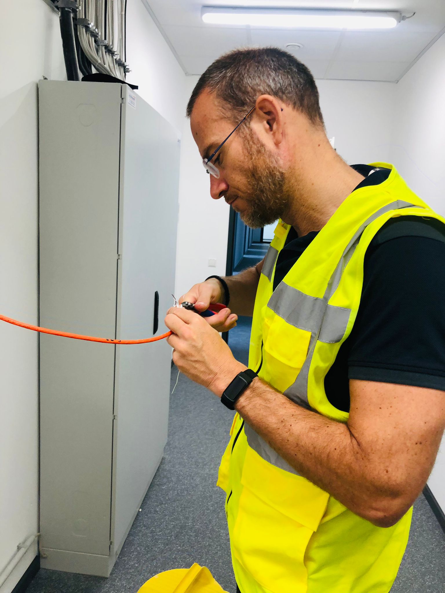 Monteur van CameraInstallatie werkt de netwerkbekabeling af in de technische ruimte van een opvanglocatie