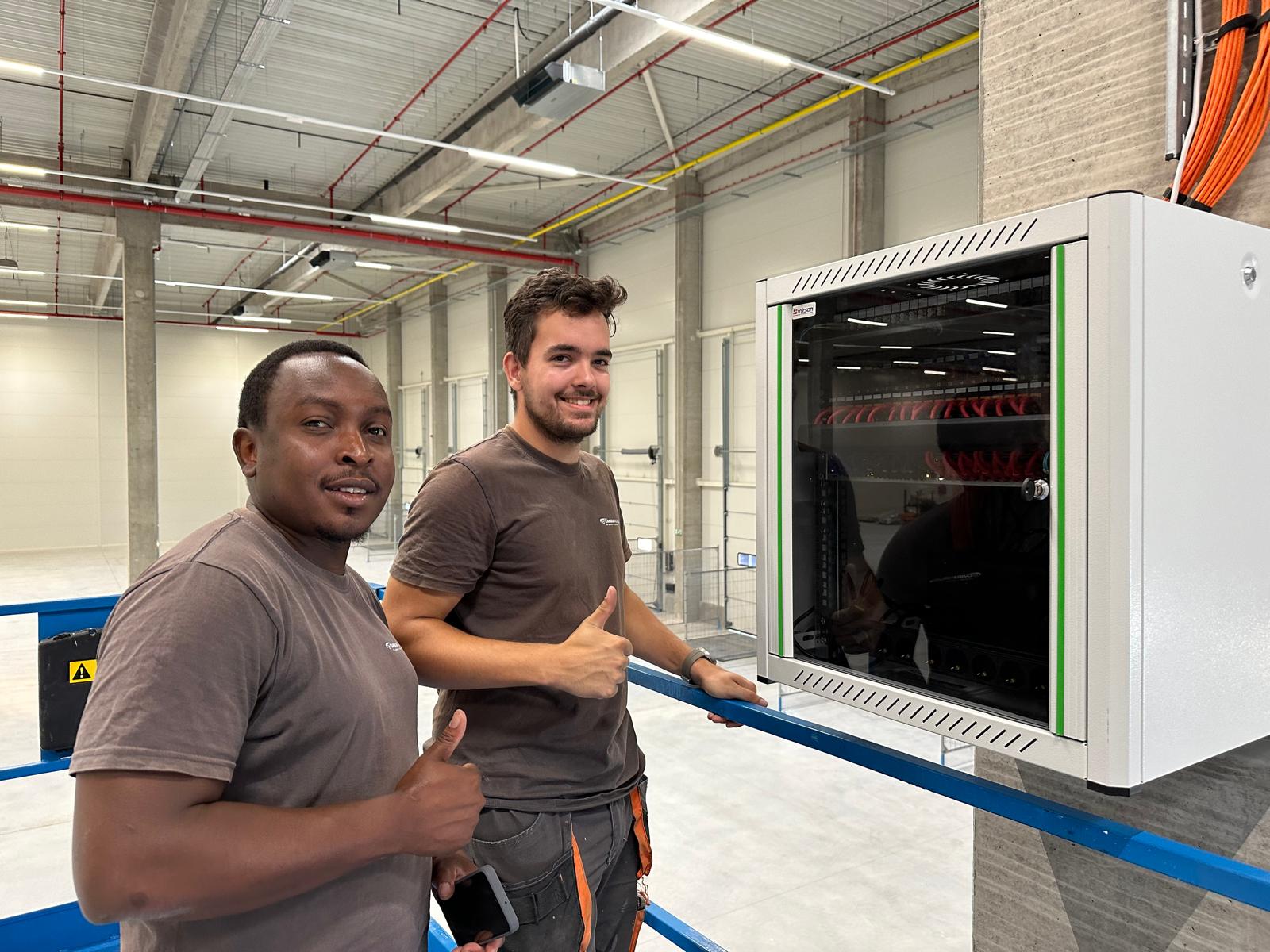 Monteurs bij een wandpatchkast op een industri&euml;le locatie