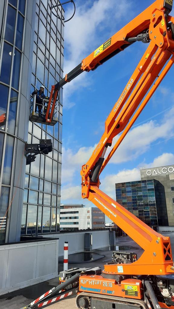 Monteurs van CameraInstallatie werken vanuit een hoogwerker aan een camera op hoogte