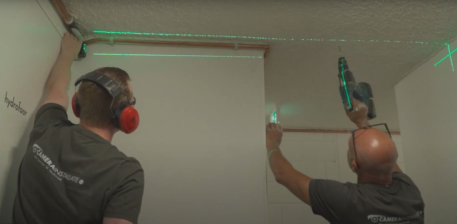 Monteurs van CameraInstallatie lijnen de camerapositie uit met een laser