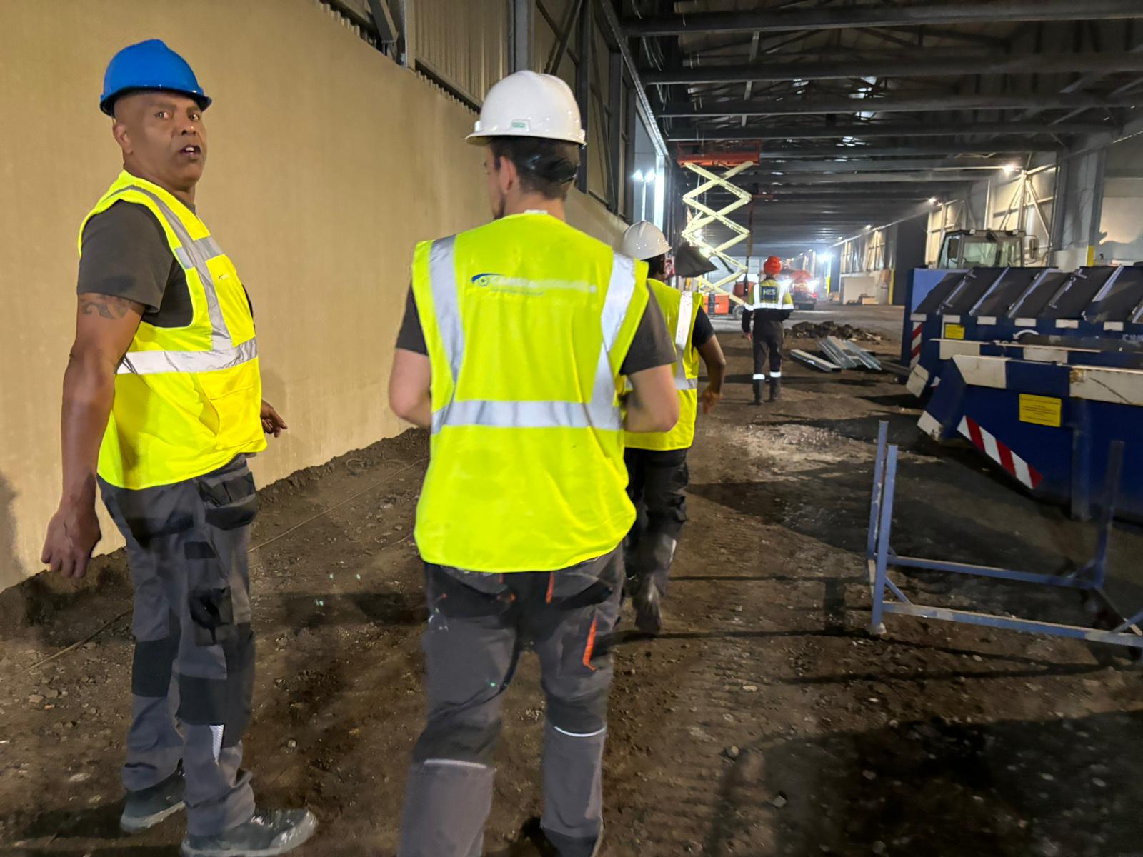 Twee monteurs overleggen op een industrieel werkterrein
