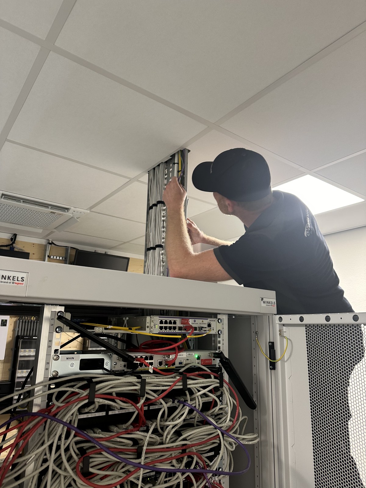 Monteur van CameraInstallatie.nl bouwt de deurcontrollers op in een technische kast