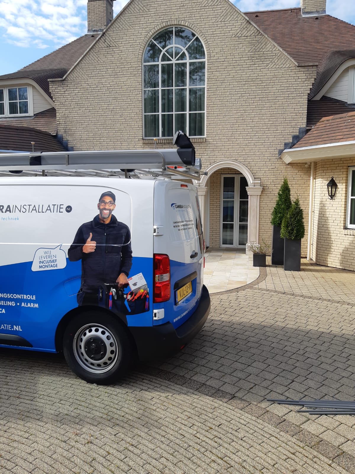 Servicebus van CameraInstallatie op de oprit van een vrijstaande woning