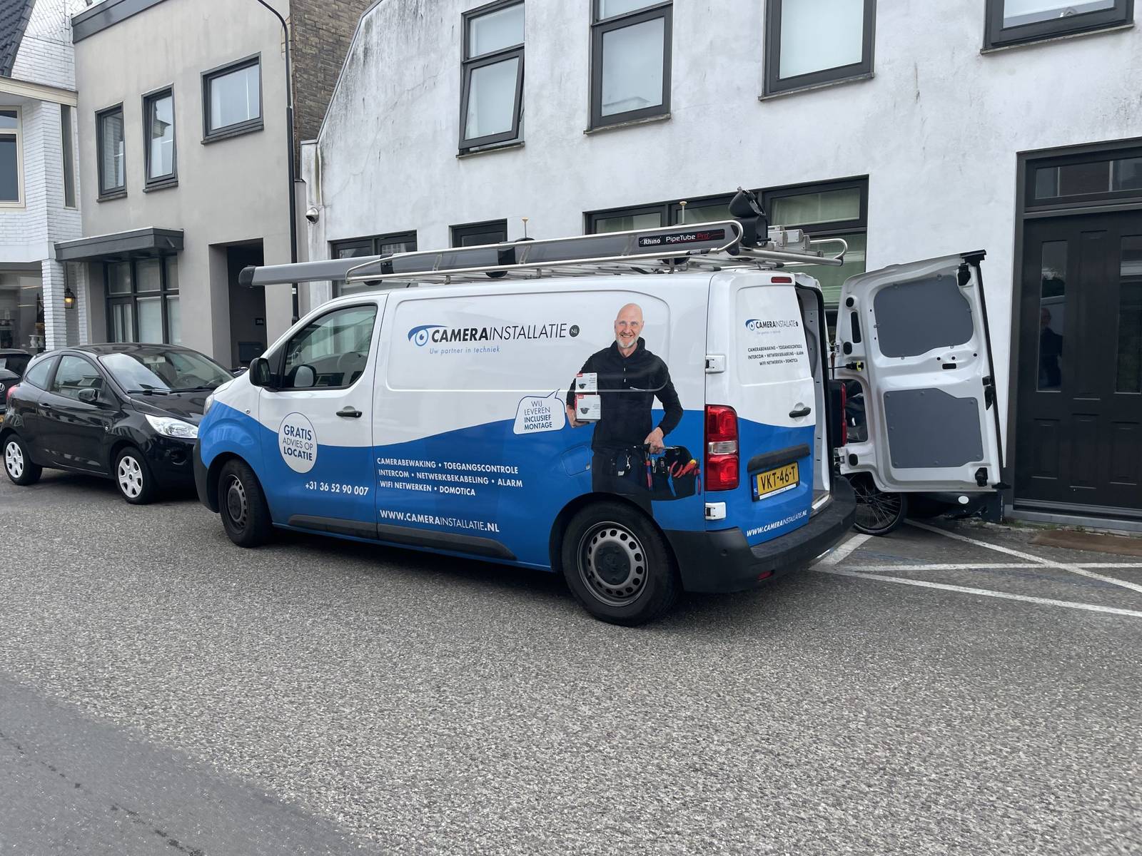 Bus van CameraInstallatie in een woonstraat tijdens het aanleggen van een alarmsysteem