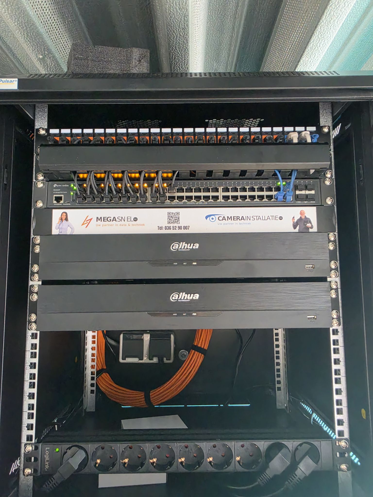 Patchkast met recorder en netjes opgerolde oranje datakabels