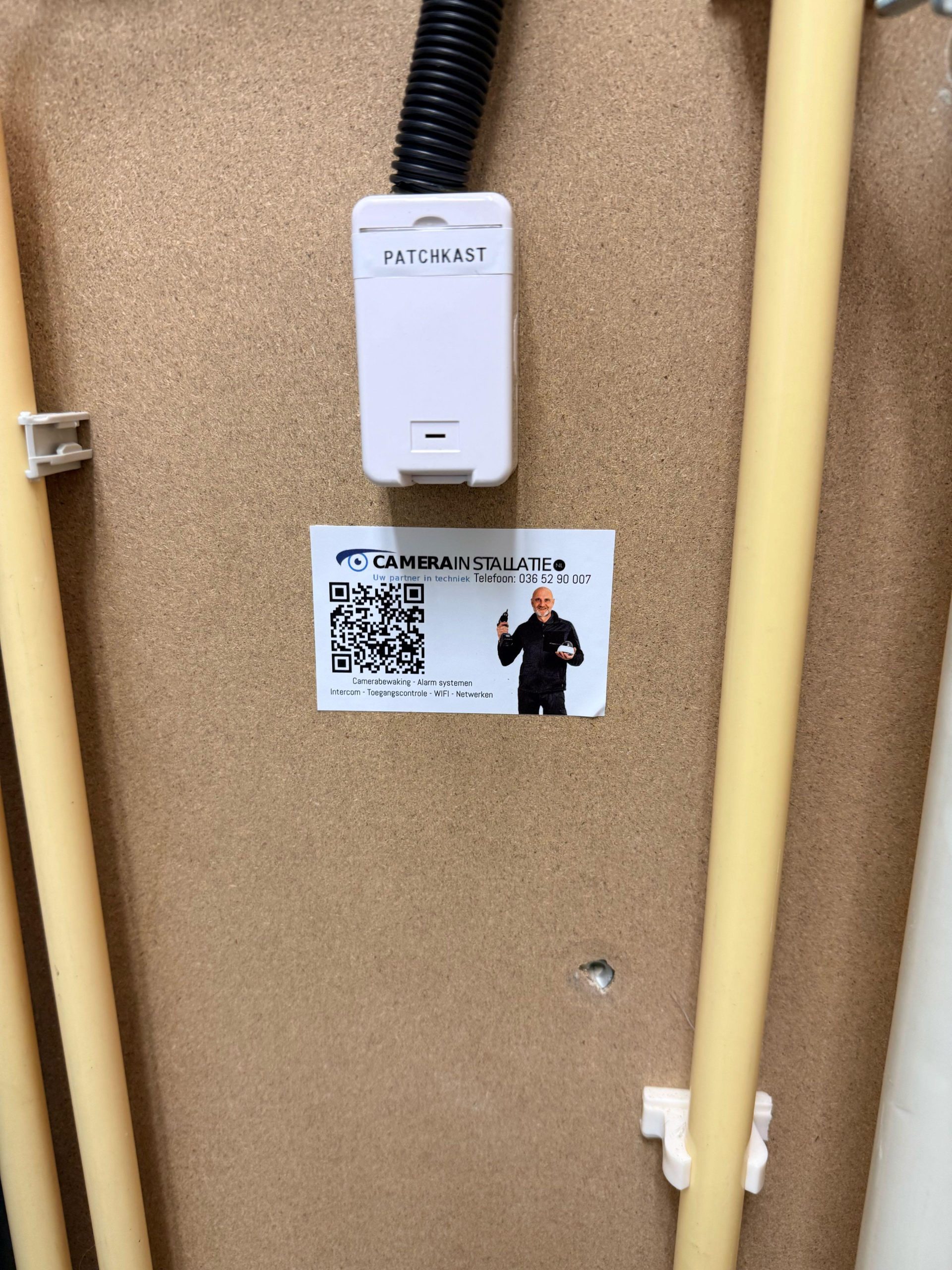 Netwerkmodule met QR-sticker van CameraInstallatie op een houten montageplaat